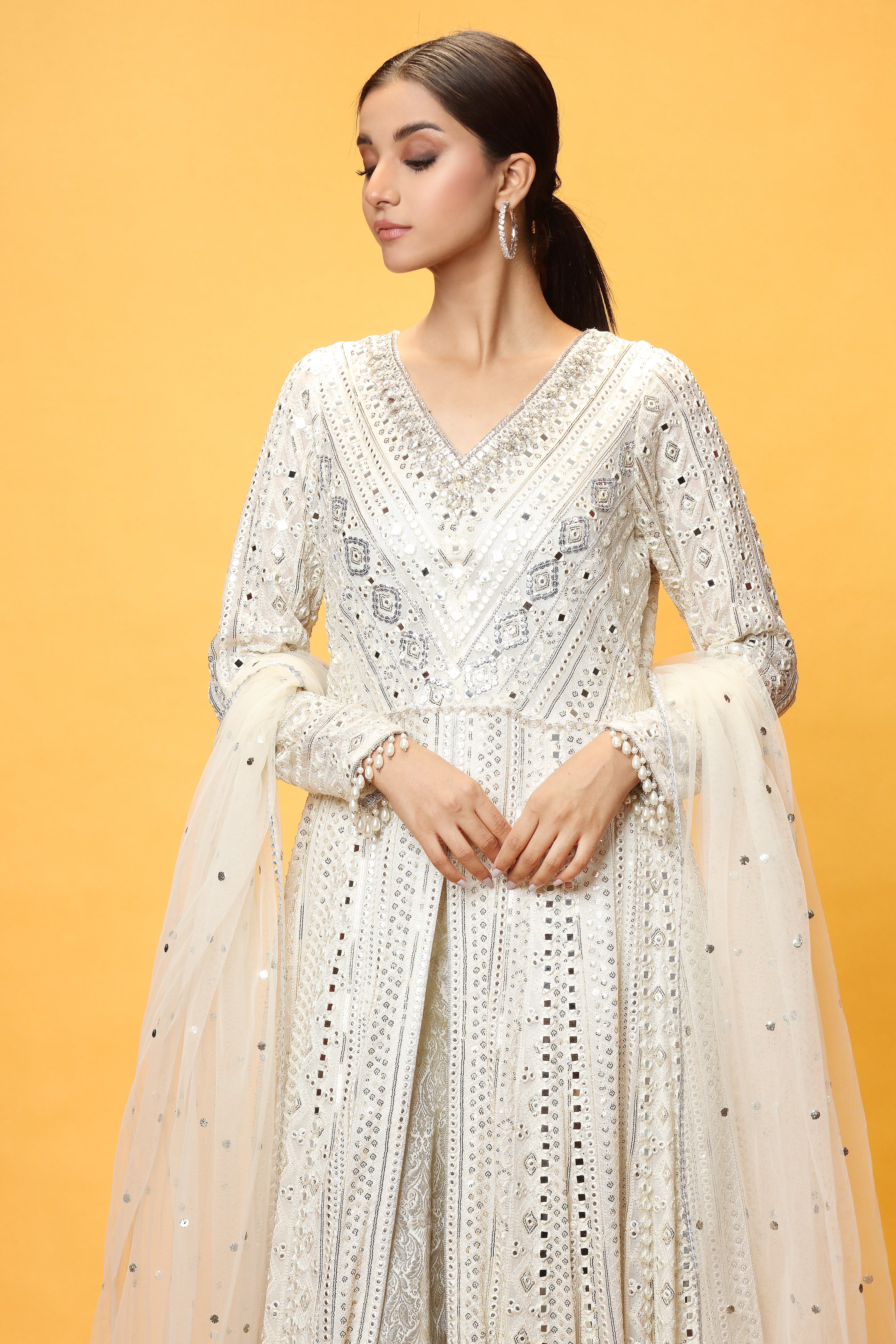 A stunning Dress made in chikanKari with Panni lines. Loaded with mirrors stitched in fabric and intricate stunning work on neckline in pearls.